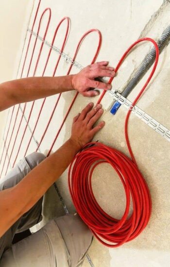 tepliy_pol_kabel_stel_1 мастер крепит кабель теплого пола на монтажную ленту