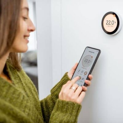 cena-na-termoregulyatory девушка настраивает WiFi терморегулятор