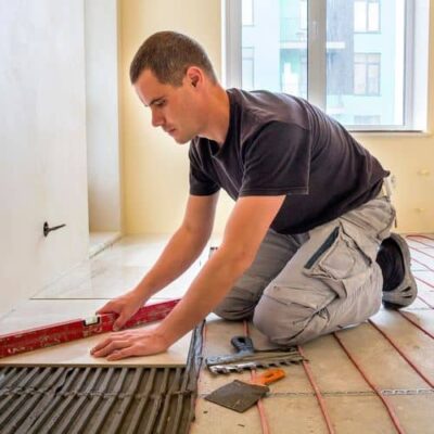 cena-na-tonkiy-kabel плиточник укладывает плитку на тонкий кабель теплого пола